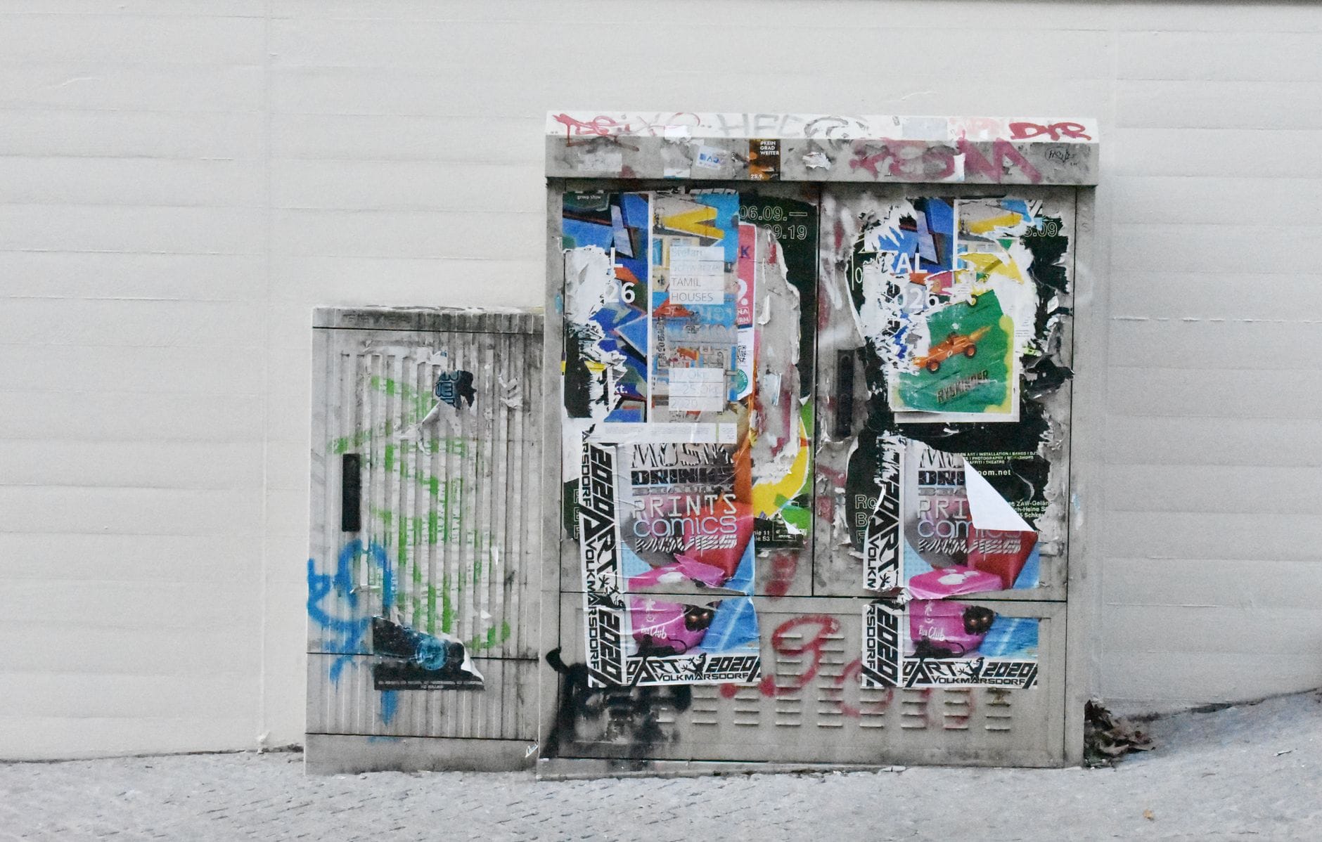 Skrzynka elektryczna oklejona plakatami i graffiti na ulicy